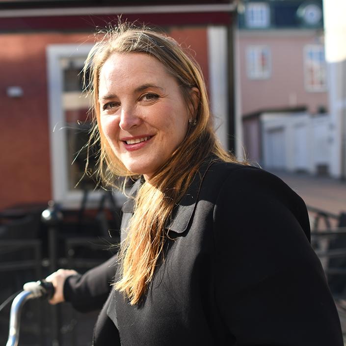 Rådgivare Therese Löwenstam Aupers står framför ett hus med en cykel